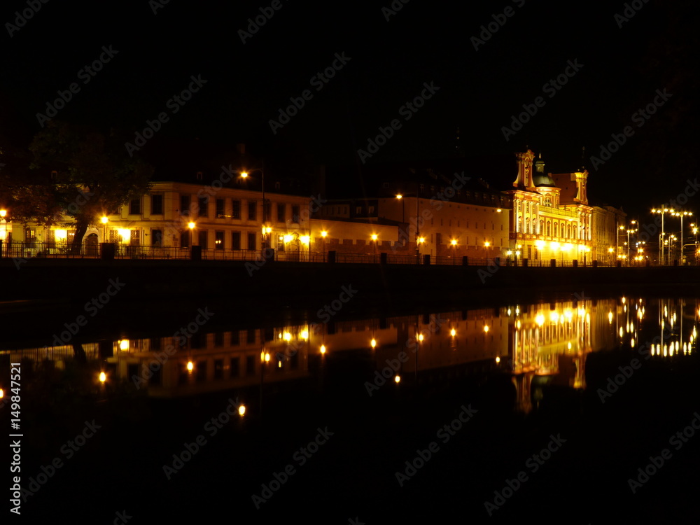 Wrocław nocą. Pięknie oświetlone budynki odbijające się w rzece Odra. Polska