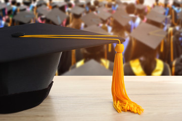 graduation cap with Yellow tassel on wood table background
