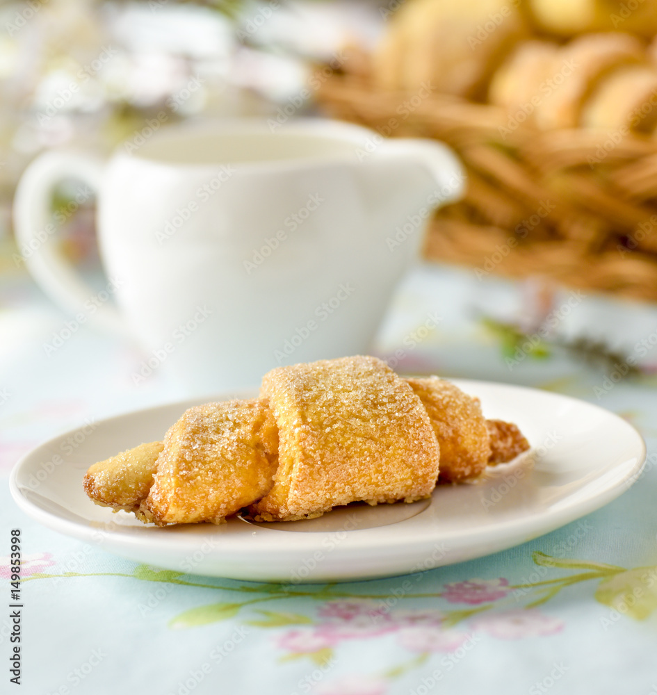 Many croissants on a table with spring flowers Many croissants on a table with spring flowers
