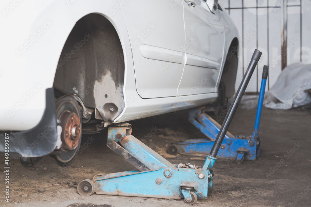 Fototapeta premium Car wheel tire replacement on tire jack