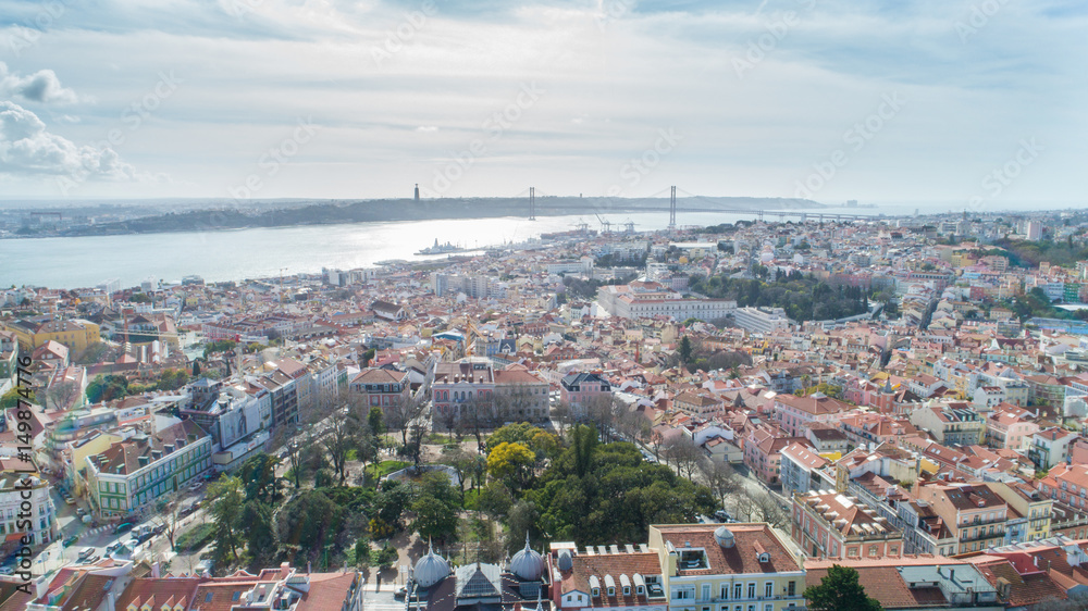 Aerial panoramic view over Lisbon in beautiful sunset sunshine.Saint George castle,downtown and neighbourhood of Alfama,river Tagus in european capital,Lisbon,Portugal.Aerial travel photography
