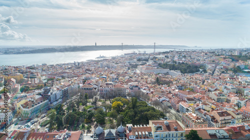 Aerial panoramic view over Lisbon in beautiful sunset sunshine.Saint George castle,downtown and neighbourhood of Alfama,river Tagus in european capital,Lisbon,Portugal.Aerial travel photography 