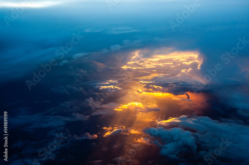 Aerial view of a cloudy sunset while flying above the clouds