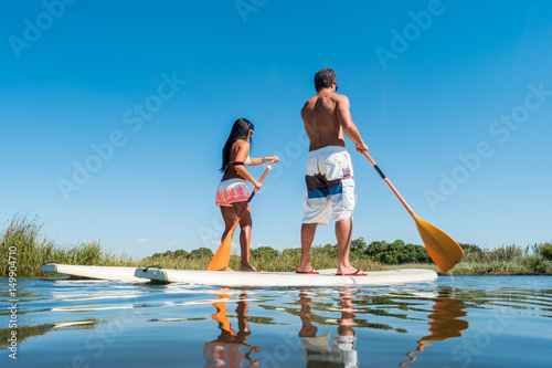 Photos Man and woman stand up paddleboarding