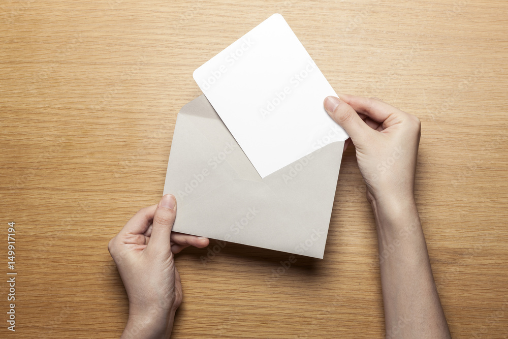 woman hand hold a envelope and letter on the wood table. woman hand hold a envelope and letter on the wood table.