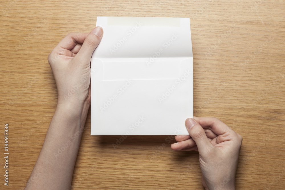 woman hand hold a letter and envelope on the wood table. woman hand hold a letter and envelope on the wood table.