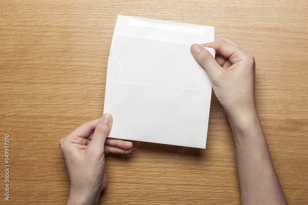 woman hand hold a letter and envelope on the wood table. woman hand hold a letter and envelope on the wood table.