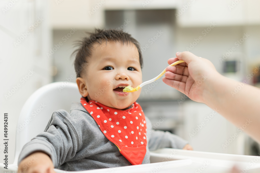 Asian baby boy eating blend food on a high chair Asian baby boy eating blend food on a high chair