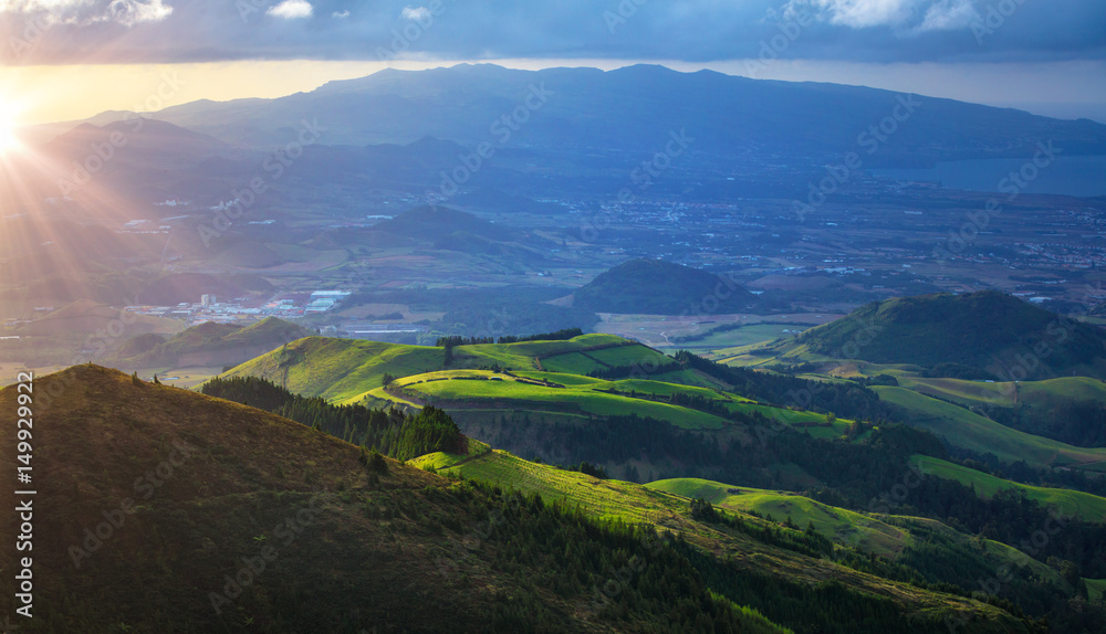 Fototapeta premium Beautiful airview at green hills on misty valley. Sunset landscape scenery with low clouds