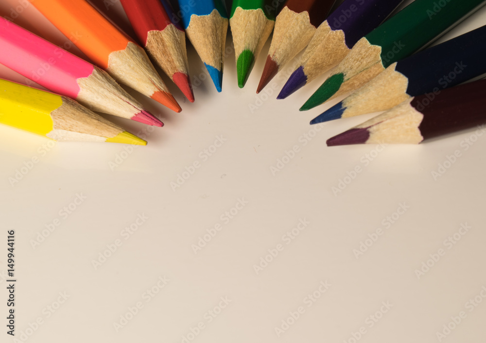 semicircle of colored pencils on white background