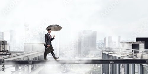 Tableau sur toile Fearless businessman overcoming difficulty. Mixed media