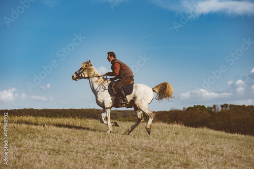 Man galloping on white horse