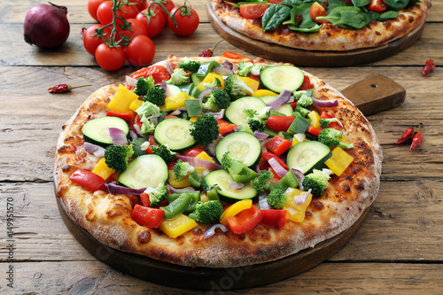 Fotografía pizza vegetariana con verdure fresche su sfondo rustico