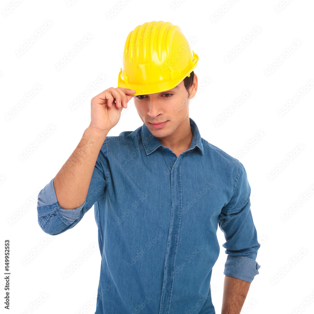 young construction engineer holding his safety helmet and looks down young construction engineer holding his safety helmet and looks down