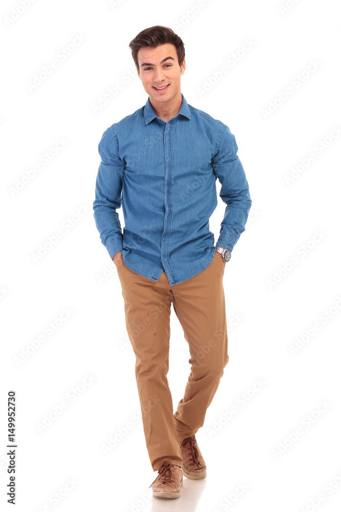 Fototapeta premium happy young casual man with hands in pockets smiling