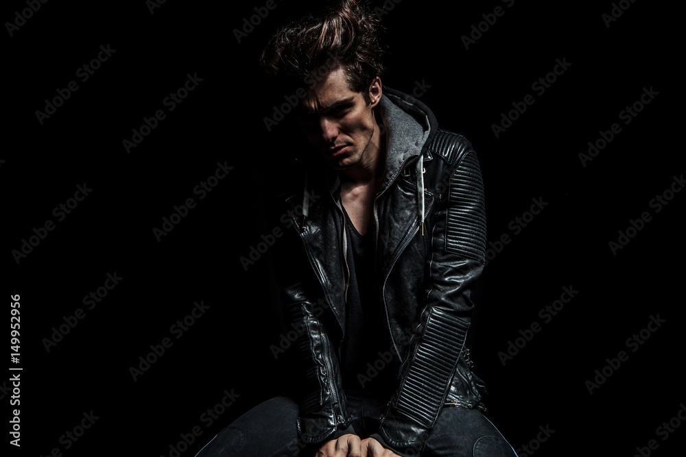 cool biker with gret hairstyle sitting on a stoo