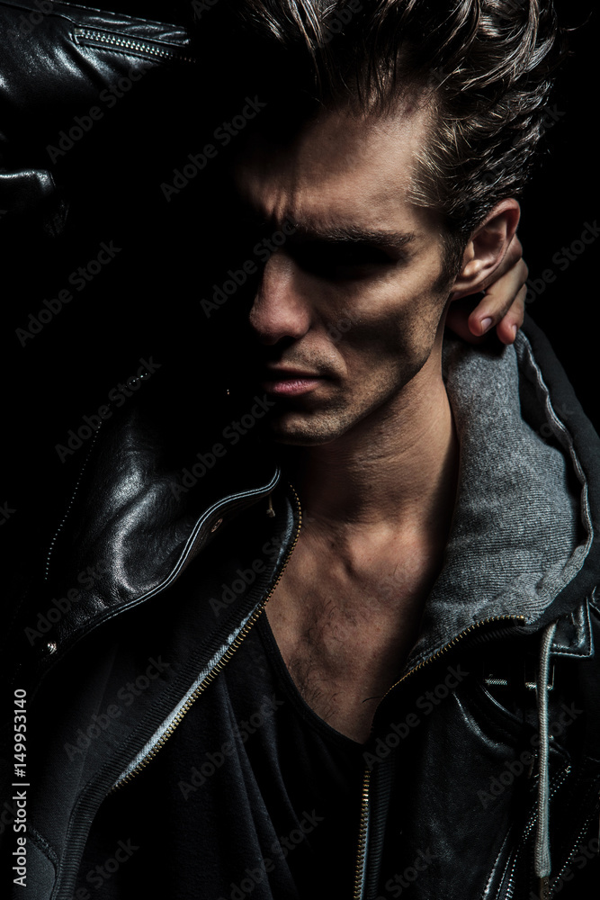 Obraz premium dramatic man holding hand behind neck and looks to side
