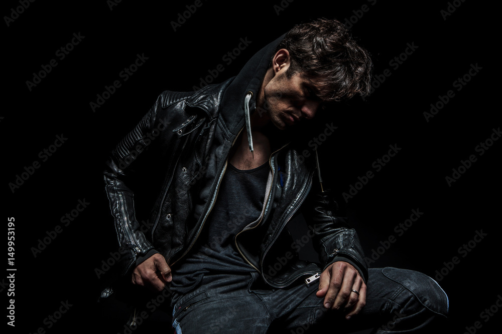 side view of a man wearing hoodie and leather jacket Stock Photo