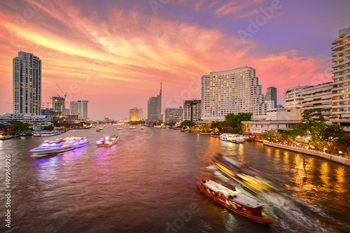 Bangkok city with business building and chao praya river with boat at twilight sunset, street view on Taksin Bridge, thailand. photo