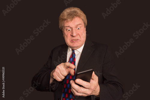 Shocking news. Surprised mature man in suit with mobile phone © Solarisys