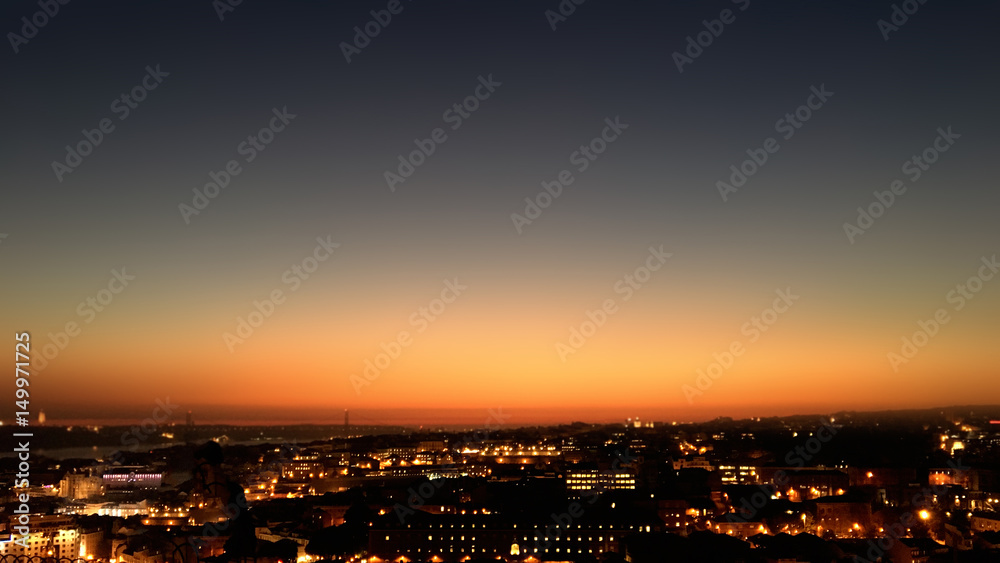 City night from the view point on top of hill at beautiful sunset. Bird view over the city at night with abstract urban night lights in Lisbon, Portugal