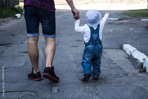 father and son holding hands walking