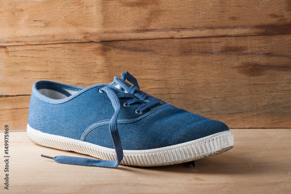 Blue sneakers close up on wood desk Blue sneakers close up on wood desk