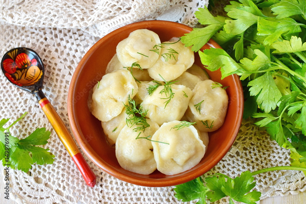 Traditional russian pelmeni with minced meat and onions filling in a brown ceramic bowl Traditional russian pelmeni with minced meat and onions filling in a brown ceramic bowl