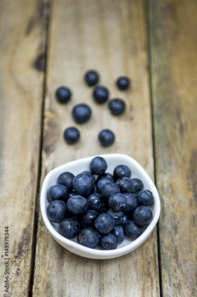 Freshly picked blueberries in wooden bowl. Juicy and fresh blueberries on rustic table