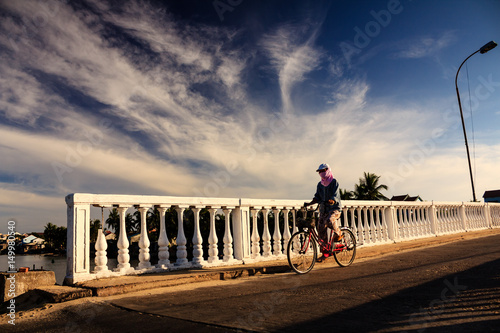 A local woman is on the bridge, Quang Nam, Vietnam. The Quang Nam province has two UNESCO World Heritage Sites: Hoi An ancient town and the My Son temple complex. photo