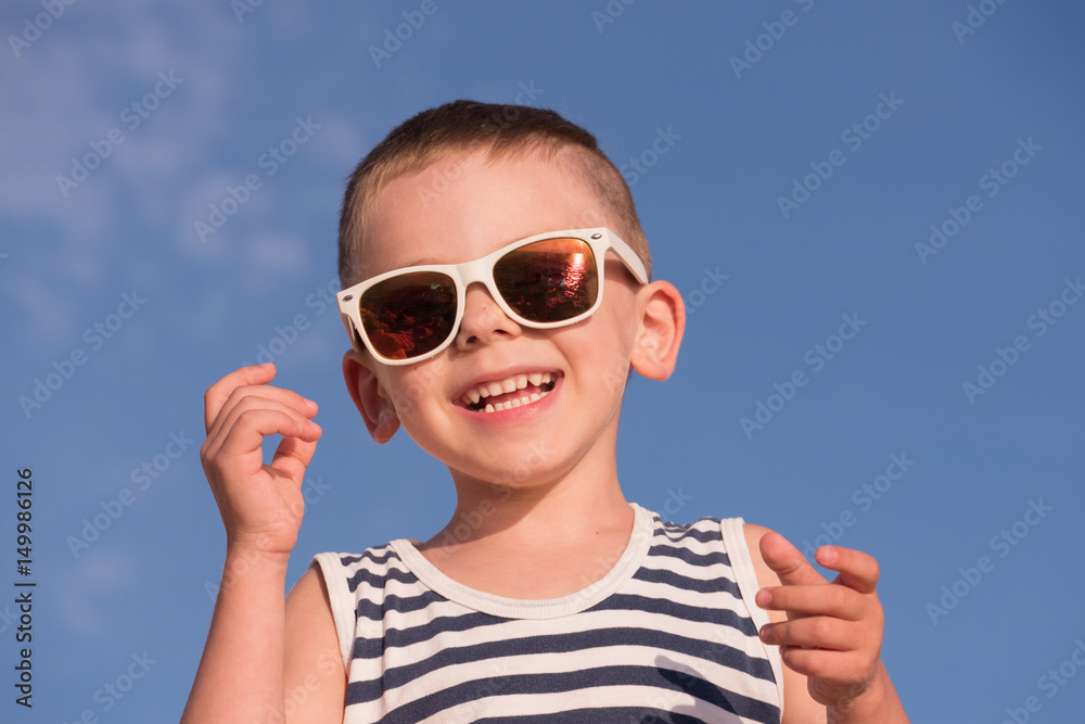 happy laughing small kid wearing sunglasses and sailor stripes shirt happy laughing small kid wearing sunglasses and sailor stripes shirt
