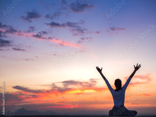 Silhouette of free woman enjoying freedom feeling happy at sunset. relaxing woman in pure happiness
