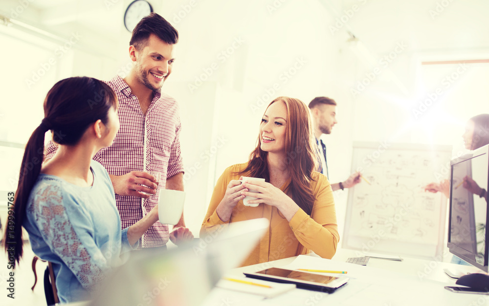 Obraz premium happy creative team drinking coffee at office