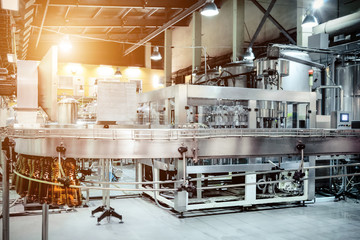 The filling machine pours beer into plastic PET bottles.