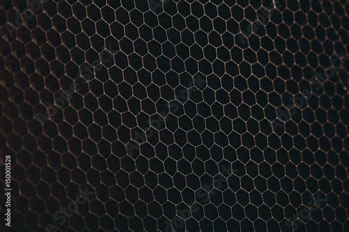 abstract texture honeycomb. Metallic net background or texture. metal mesh. full frame colourful illuminated detail of a metallic grid in front of a loudspeaker. Colorful abstract background.