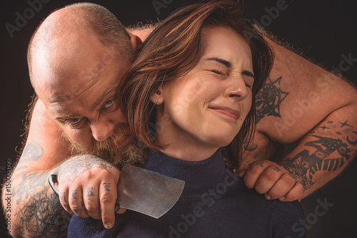 Man holding a knife to a woman's neck photo