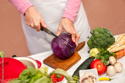 Woman slicing red cabbage in the kitchen
