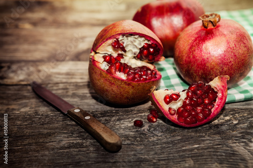 Tableau sur toile Red juicy pomegranate with knife on the table