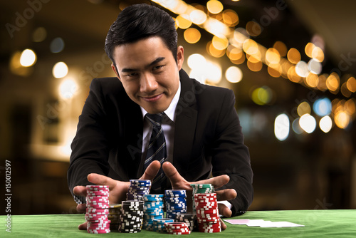 Foto Portrait the poker Player used hands push stack chips forward to betting