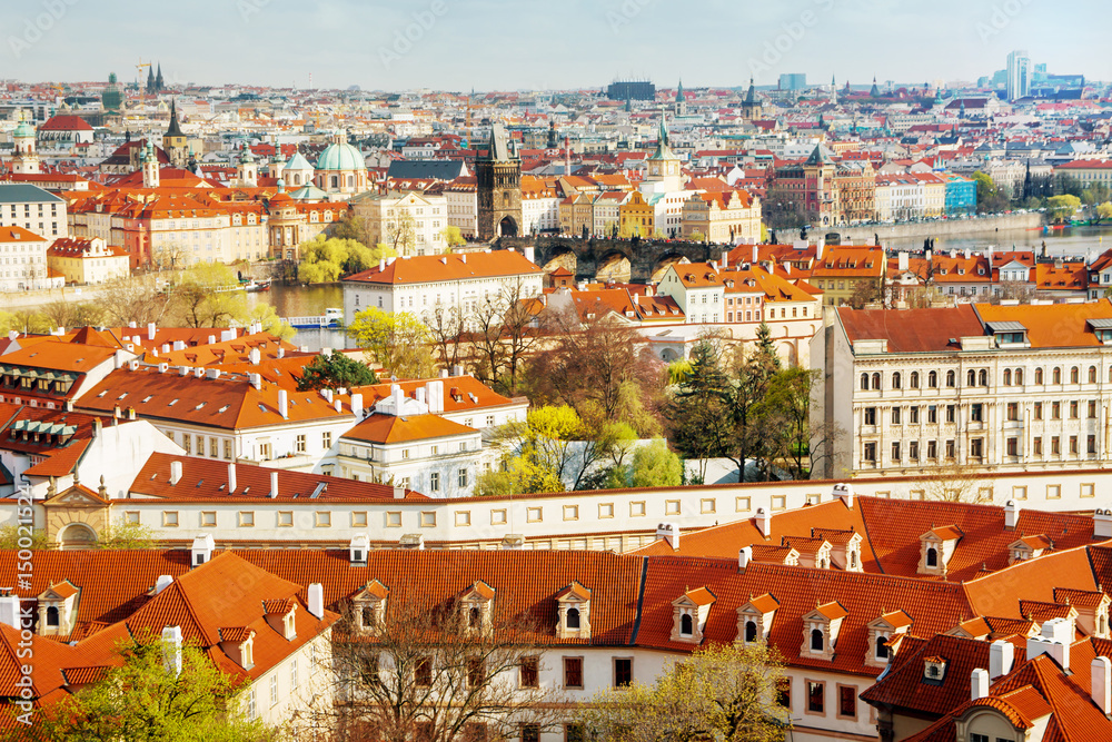 Buildings and churches with red rooftops in old city in Prague