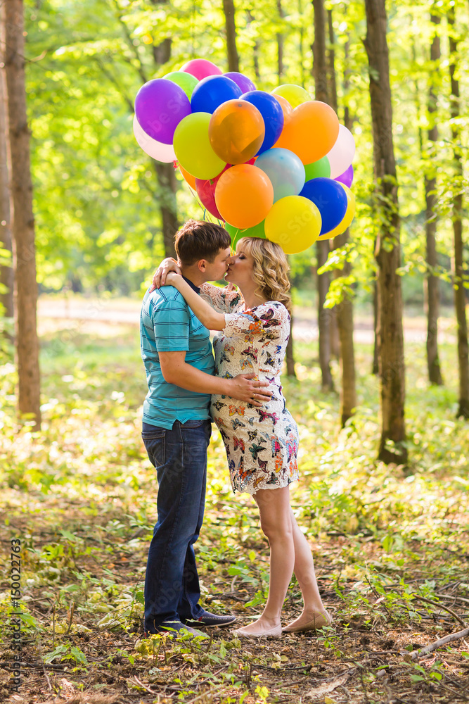 Fototapeta premium young couple man and his pregnant wife with balloons outdoors