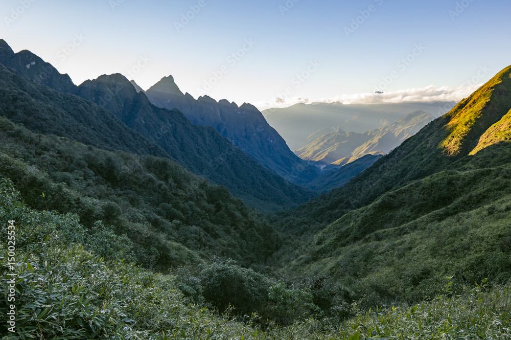 Obraz premium Colorful sunset over the mountains view on the way to Fansipan (Fan Si Pan or Phan Xi Pang) - the highest mountain in Indochina located in Hoang Lien Son mountain range, Lao Cai Province, Vietnam