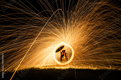 Abstract background from spinning steel wool on cliff at night time