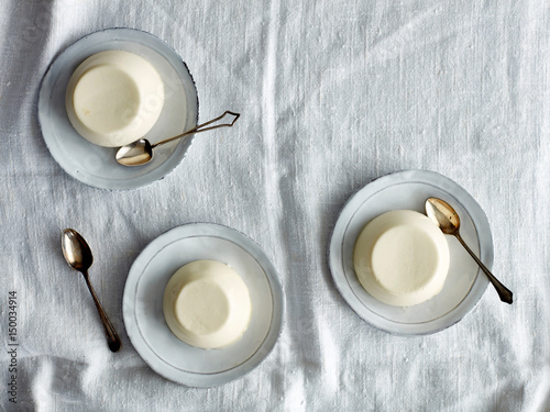 Overhead view of panna cotta desserts on saucers photo