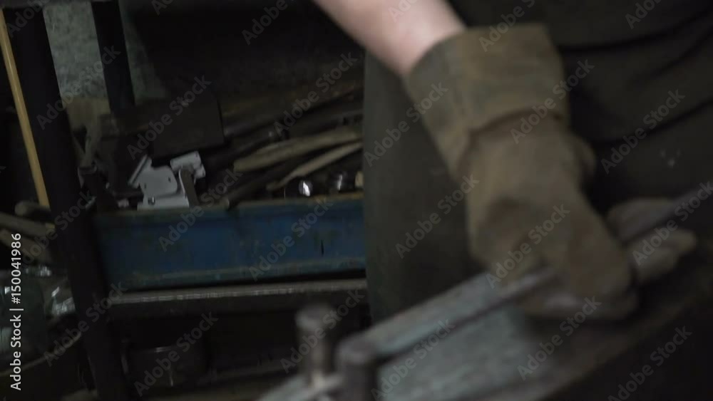 the blacksmith makes metal candle holder with rose and horseshoe. the blacksmith makes metal candle holder with rose and horseshoe.