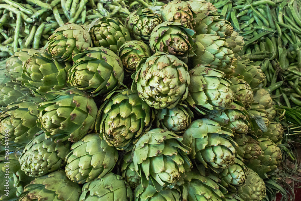 Obraz premium A big stack of fresh green delicious artichokes and green beans for them