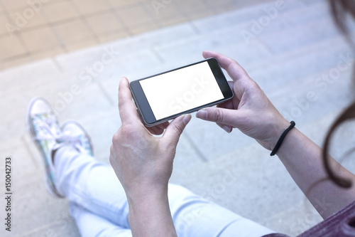 Woman holding modern smartphone. Horizontal mockup. Replaceable with own design. Landscape mode, 16:9 aspect ratio.Top view.