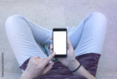 Woman holding modern smartphone. Horizontal mockup. Replaceable with own design. Portrait mode, 16:9 aspect ratio.Top view.