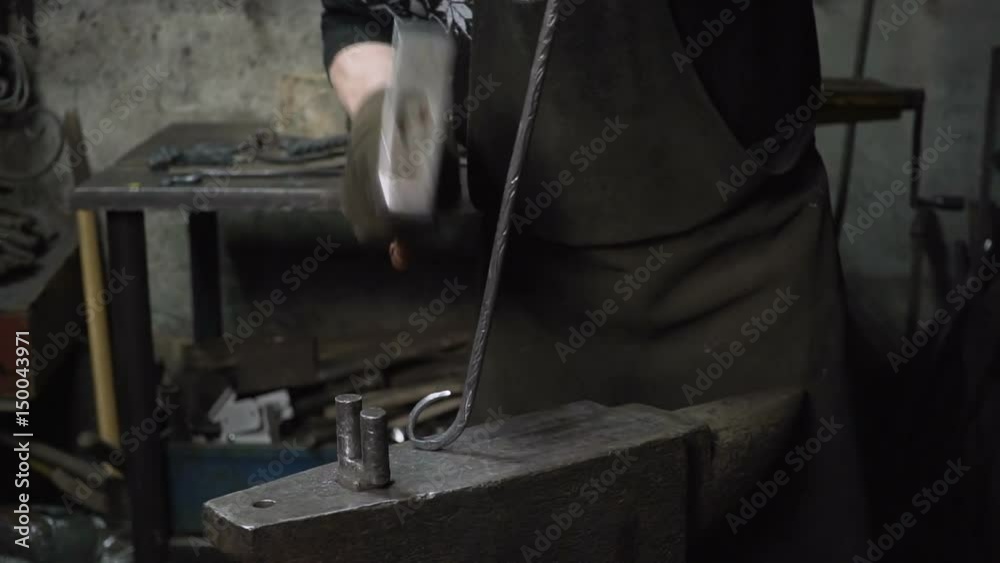 the blacksmith makes metal candle holder with rose and horseshoe. the blacksmith makes metal candle holder with rose and horseshoe.