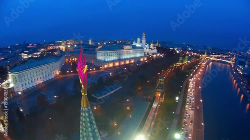 Moscow capital Russia Grand Kremlin Palace big red star. Central Embankment  River. Old and modern buildings. City night illumination panorama. Active Road Traffic Summer. Aerial Flight above close to
